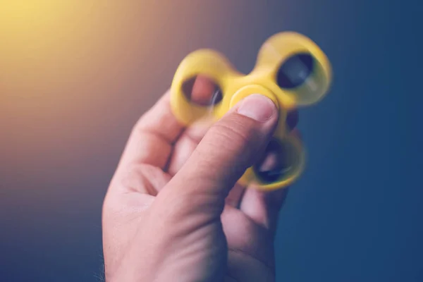 Yellow fidget spinner in male hand — Stock Photo, Image