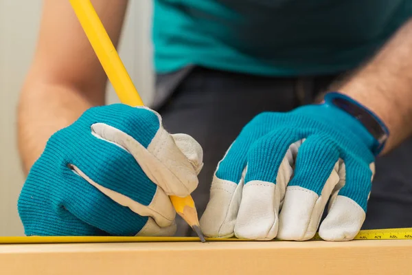 Carpenter handyman using pencil to mark the plank — Stock Photo, Image