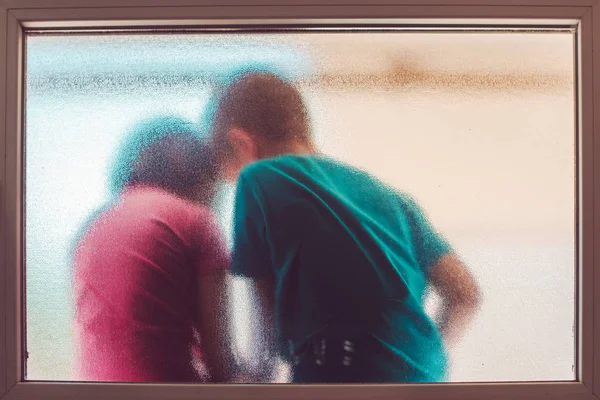 Tanınmayan erkek ve kız vitray pencere arkasında — Stok fotoğraf