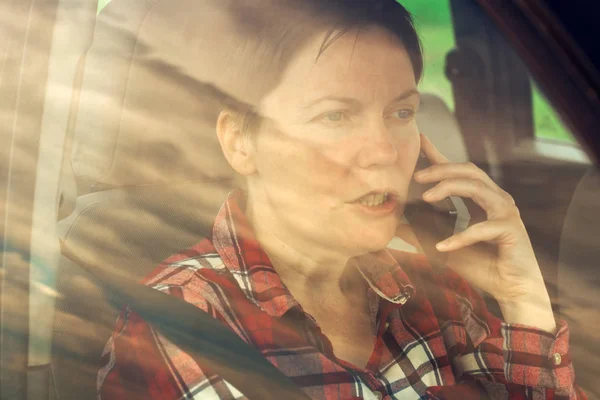 Mujer preocupada hablando por teléfono móvil en coche — Foto de Stock