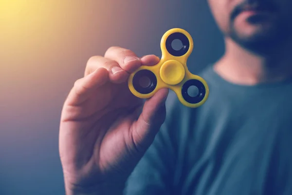 Spinner fidget amarillo en mano masculina — Foto de Stock