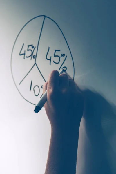 Businesswoman drawing pie chart on office whiteboard — Stock Photo, Image