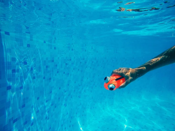 Kind spelen met generieke rubber vis speelgoed in zwembad — Stockfoto