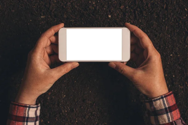 Samica rolnika, trzymając smartfon z udawanym pusty ekran — Zdjęcie stockowe