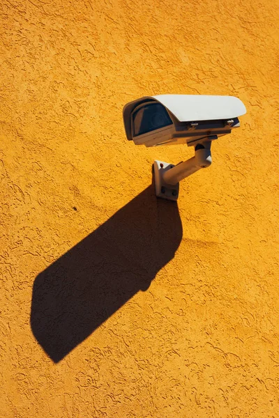 Security camera on yellow wall — Stock Photo, Image