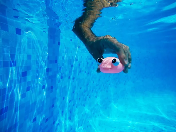 Homme jouant avec jouet de poisson en caoutchouc générique dans la piscine — Photo