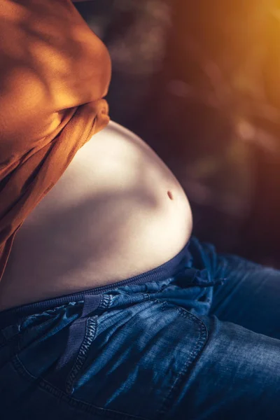 Gravid kvinna avkopplande och sola magen — Stockfoto