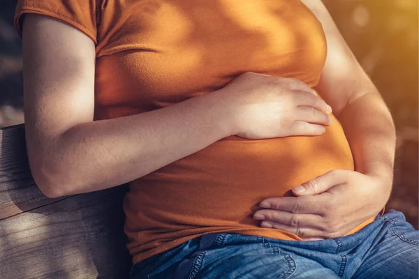 Mulher grávida relaxante e banhos de sol barriga — Fotografia de Stock