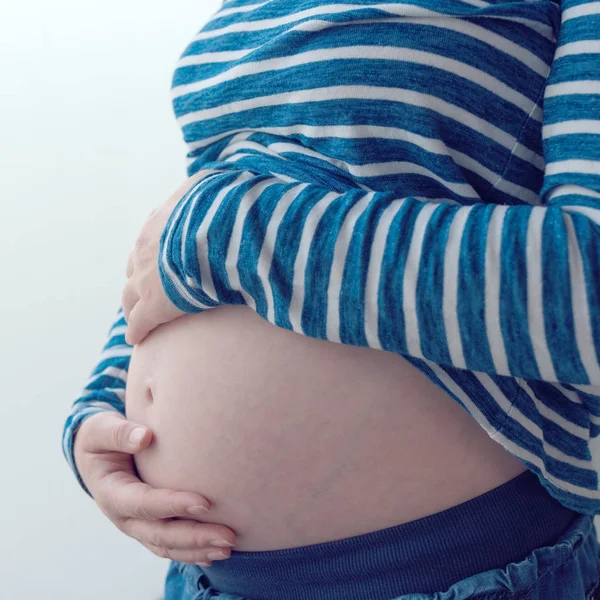 Gravid kvinna att röra och gnugga hennes mage — Stockfoto