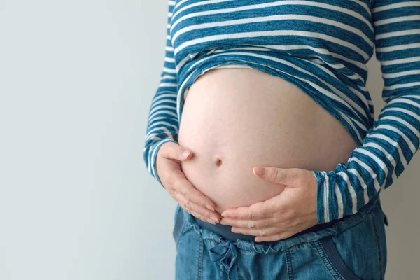 Gravid kvinna att röra och gnugga hennes mage — Stockfoto