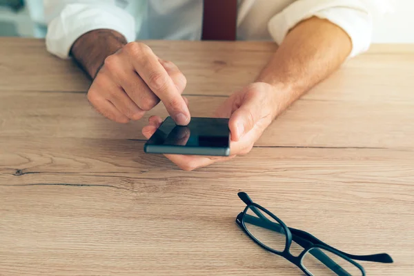 Smartphone i händerna på framgångsrik affärsman — Stockfoto