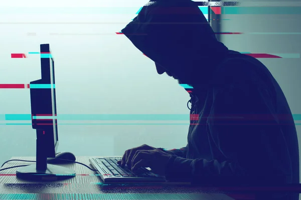 Hooded computer hacker working on desktop PC computer — Stock Photo, Image