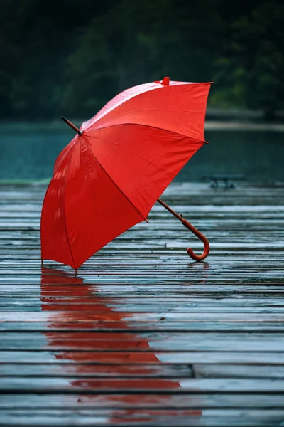 Red umbrella on dock — Stock Photo, Image