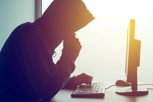 Hooded computer hacker hacking network — Stock Photo, Image