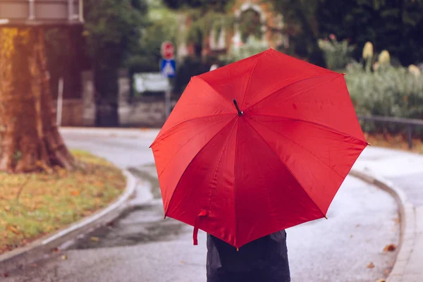 Mulher com guarda-chuva vermelho andando na rua — Fotografia de Stock