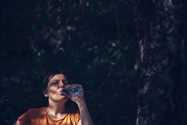 Woman drinking water outdoors — Stock Photo, Image