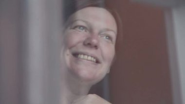 Mutlu kadın pencerenin gülümseyen