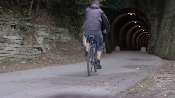 Άνδρας ιππασία ποδήλατο μέσα και έξω από το τούνελ — Αρχείο Βίντεο