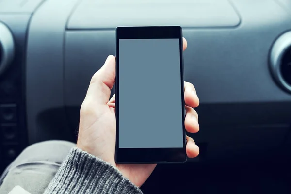 Mann hält Handy mit leerem Bildschirm im Auto — Stockfoto