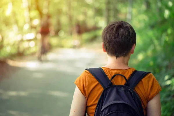 Kvinna med ryggsäck njuter promenad i parken — Stockfoto