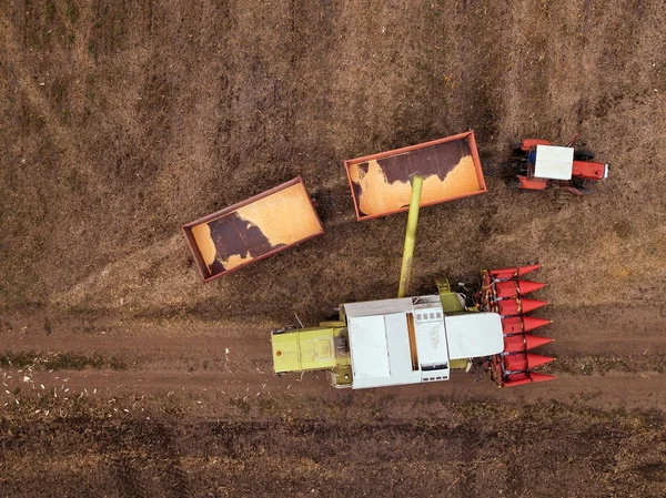 Aerial view of combine pouring harvested corn grains into traile — Stock Photo, Image