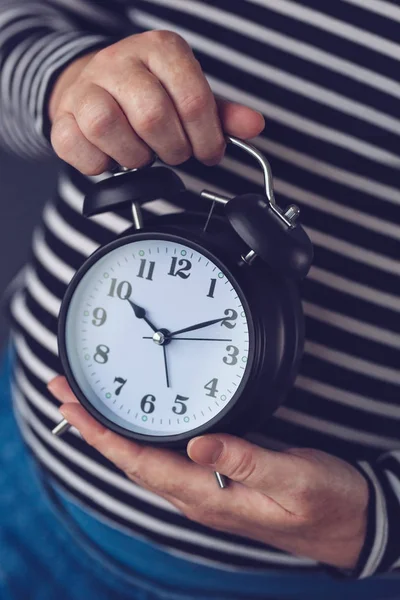 El tiempo pasa, mano femenina con reloj despertador vintage —  Fotos de Stock