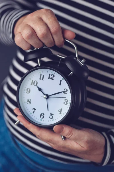 Tijd is voorbij, vrouwelijke hand met vintage wekker — Stockfoto