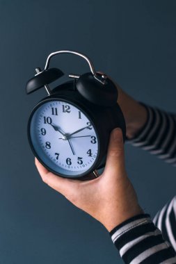 Woman winding retro alarm clock clipart