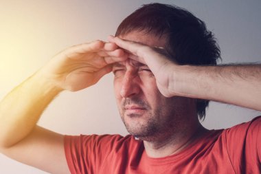 Parlak ışık kaynağı doğru bakan adam
