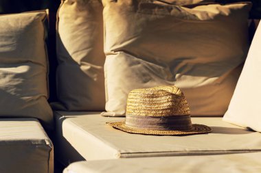 Havuz kenarında şezlong üzerinde hasır şapka