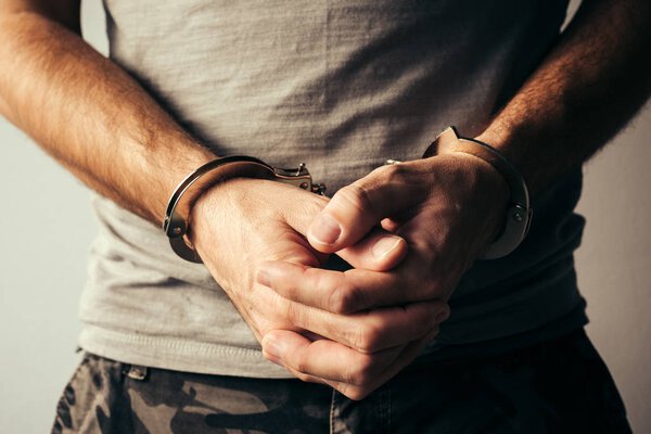 В наручниках солдат в военной одежде
