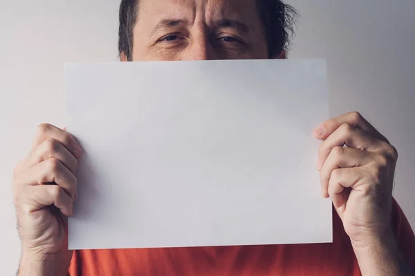 Hombre escondido detrás de papel blanco en blanco — Foto de Stock