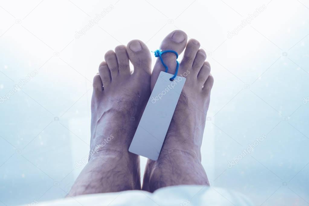 Feet of dead male person in morgue