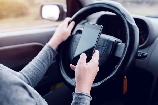 Mujer conduciendo simultáneamente coche y leyendo mensaje de texto — Foto de Stock