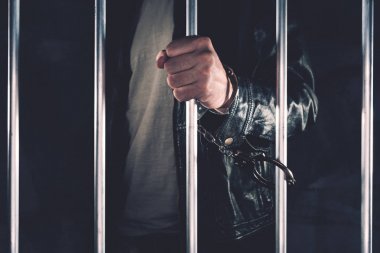 Cezaevi parmaklıklar arkasında kelepçeli erkek