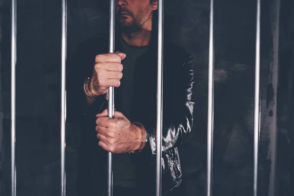 刑務所バーの後ろに手錠をかけられ男 — ストック写真