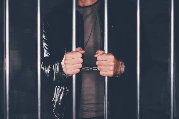 Homem algemado atrás das grades da prisão — Fotografia de Stock