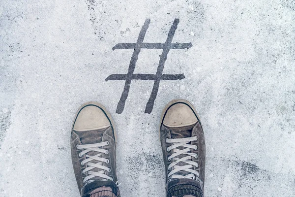 Nohy stojící nad hashtag otisk na ulici — Stock fotografie