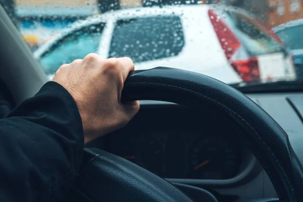 Mano masculina en el volante del coche en el tráfico urbano —  Fotos de Stock