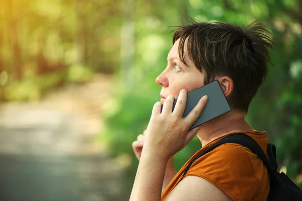 Woman talking on mobile phone in park — Stock Photo, Image