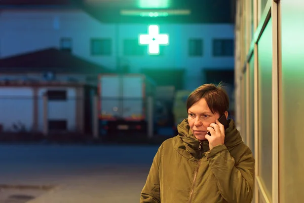 Bezorgd vrouw praten op mobiele telefoon voor drogisterij — Stockfoto