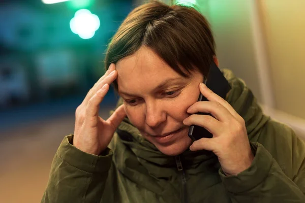 Orolig kvinna talar på mobiltelefon framför apotek — Stockfoto