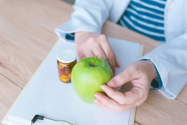 Доктор консультує яблуко замість таблеток і антибіотиків — стокове фото