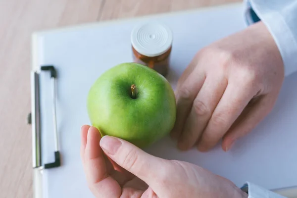 Доктор консультує яблуко замість таблеток і антибіотиків — стокове фото