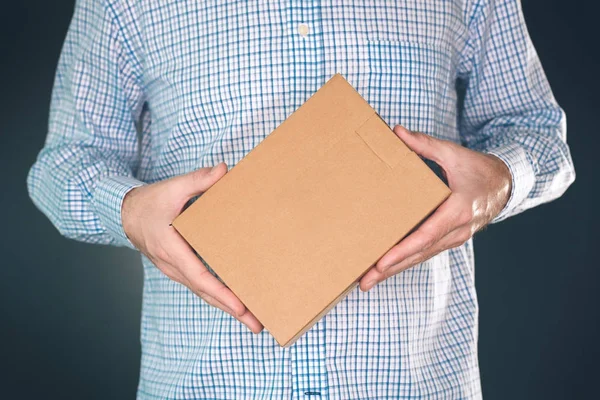 Чоловік тримає пакет картонної коробки для маскування дизайну — стокове фото