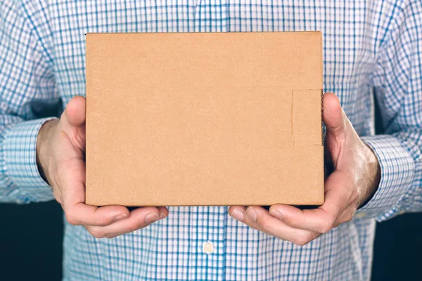 Man holding cardboard box package for mock up design — Stock Photo, Image