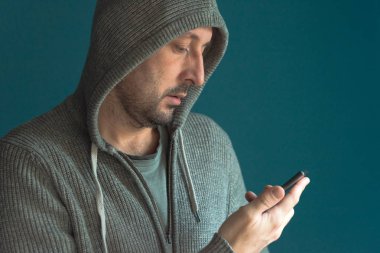 Casual adam cep telefonu ekranına bakarak