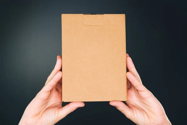 Man holding cardboard box package for mock up design — Stock Photo, Image