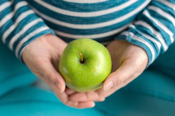 Вагітна жінка тримає зелене яблуко — стокове фото
