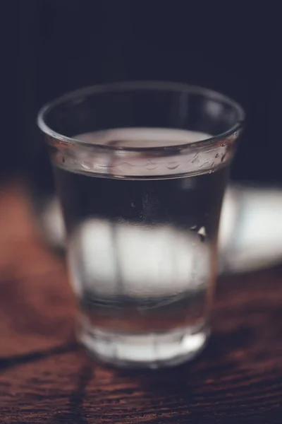 Silného alkoholu nápoj v lahvi s shot glass — Stock fotografie